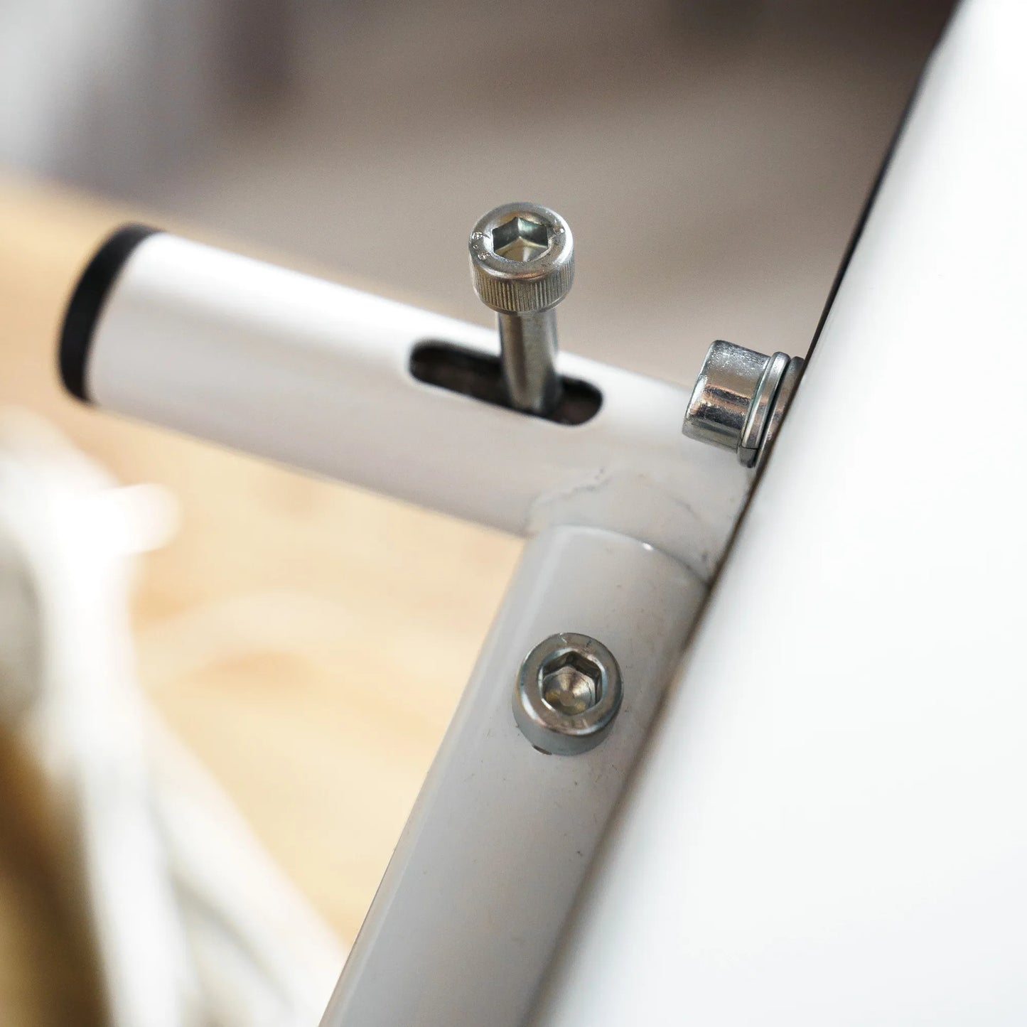 Close-up of a bicycle frame with screws and a bolt.